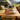 Cordless electric fondue set pot on a camping table with a scenic background